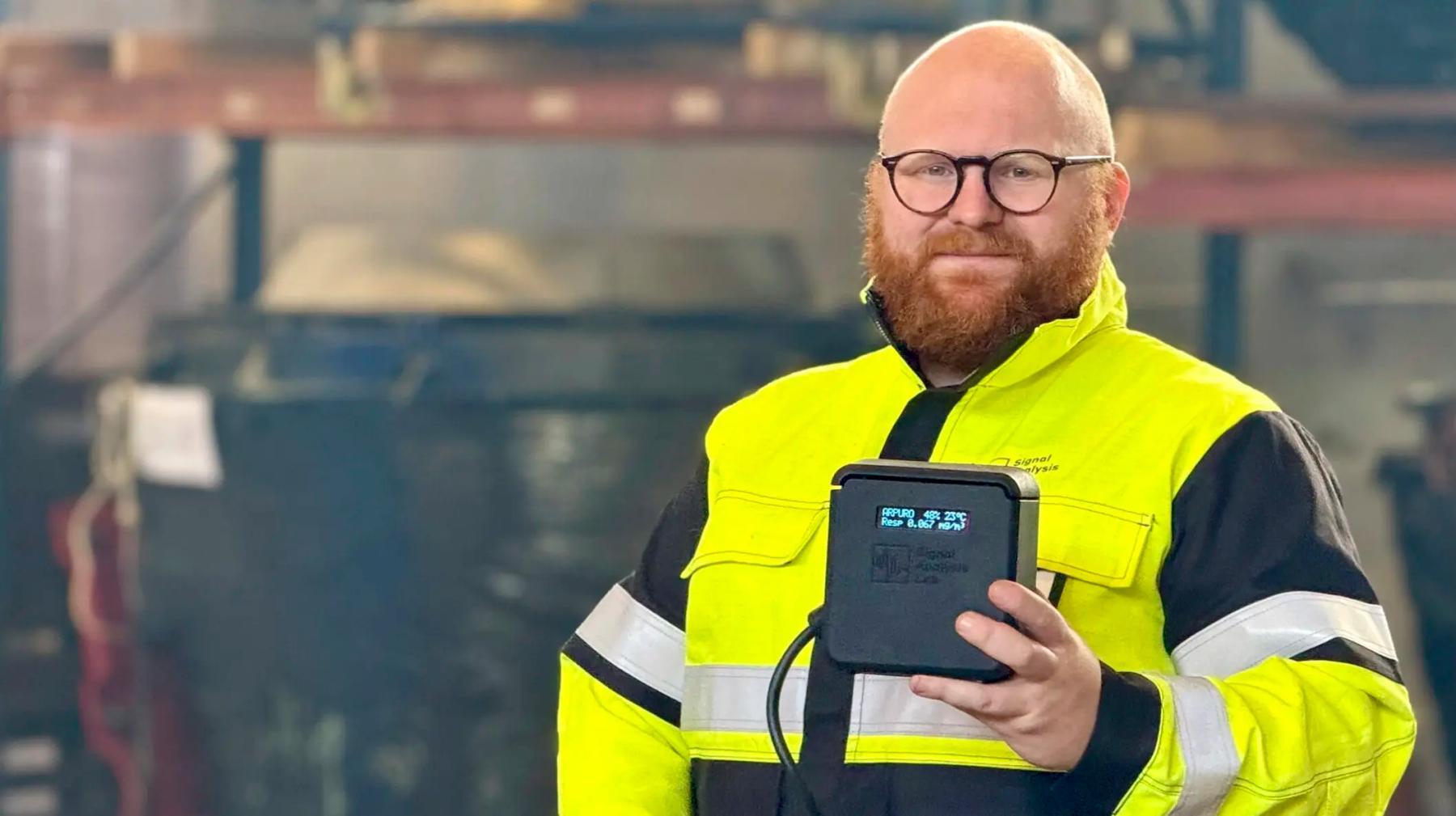 CEO in Signal Analysis Lab, Geir Kulia, holding the airborne dust monitor